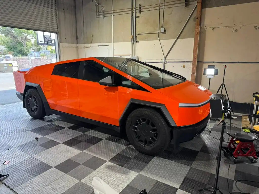 Bright orange Tesla Cybertruck prototype in a raw, unfinished state.