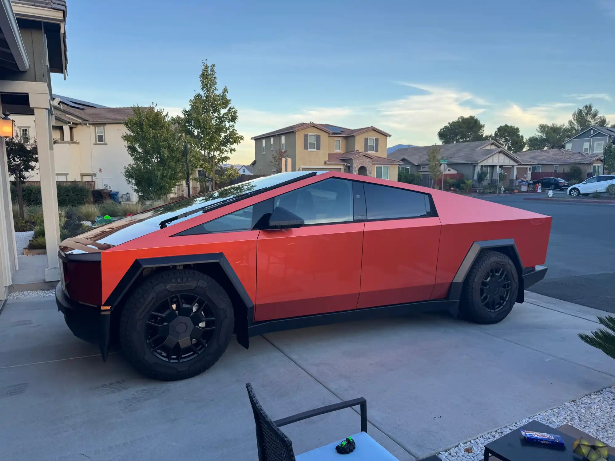 Red Tesla Cybertruck parked in a driveway.