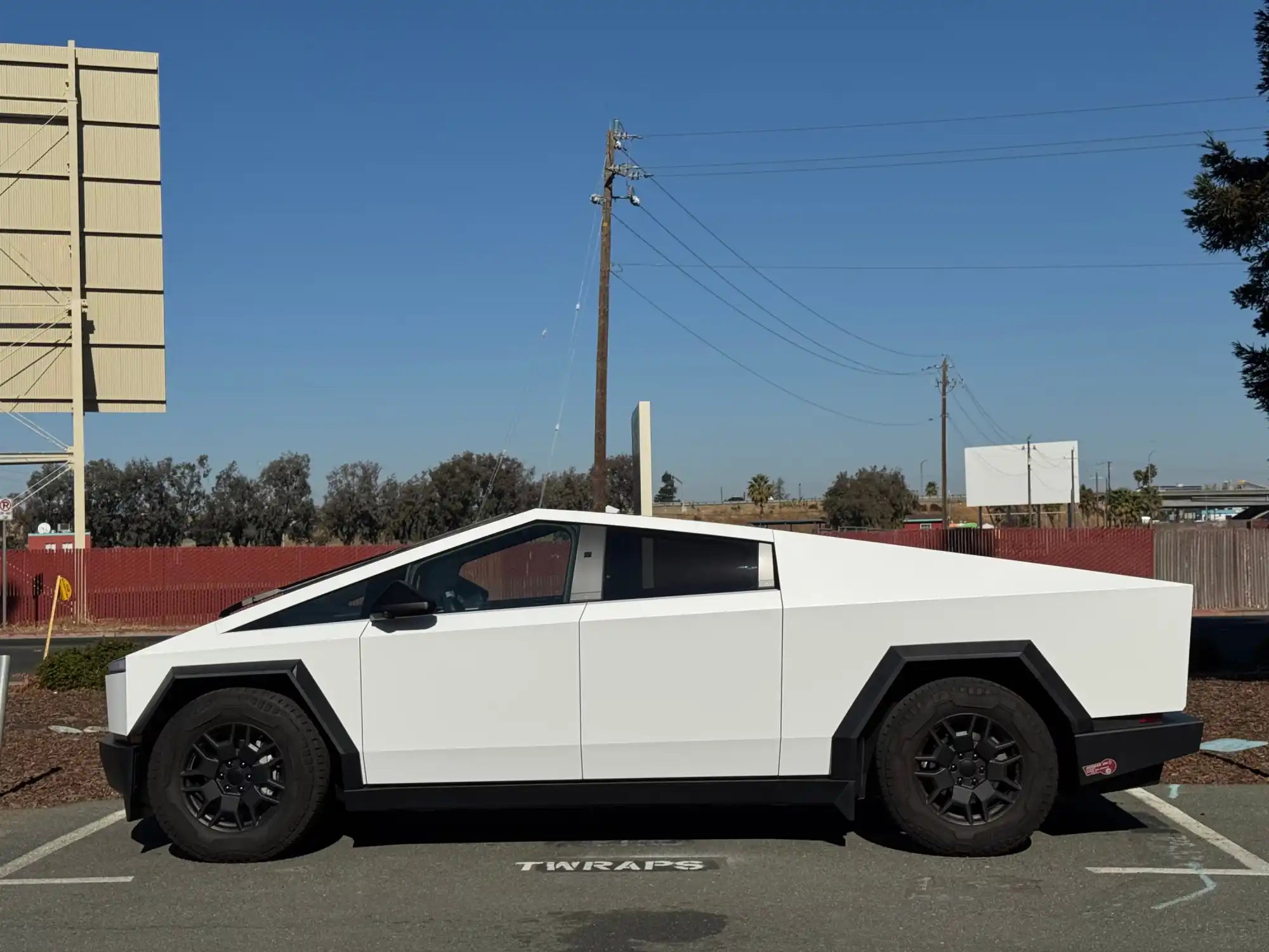 White Tesla Cybertruck parked with black wheels.